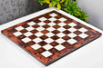 Reddish brown burl grain tournament chess board photographed from above
