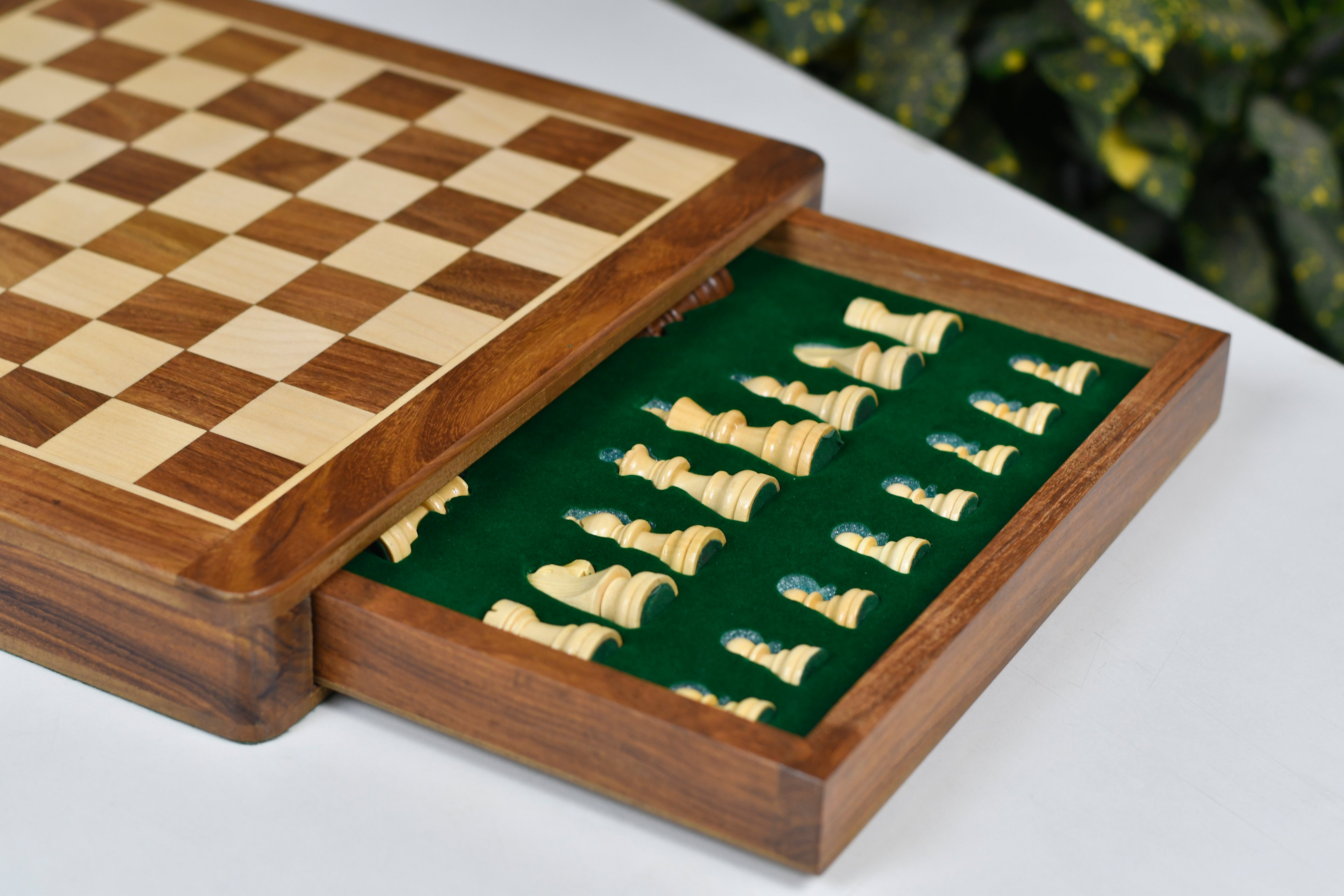 Sheesham chess pieces set up for play on the included 30cm sheesham and maple travel board