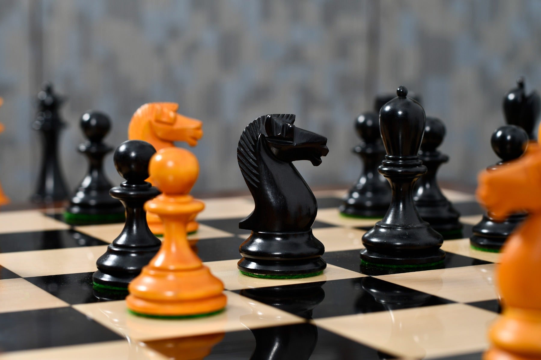 Genuine ebony chess pieces set up for play on the included 58cm ebony and maple board with a sheesham border