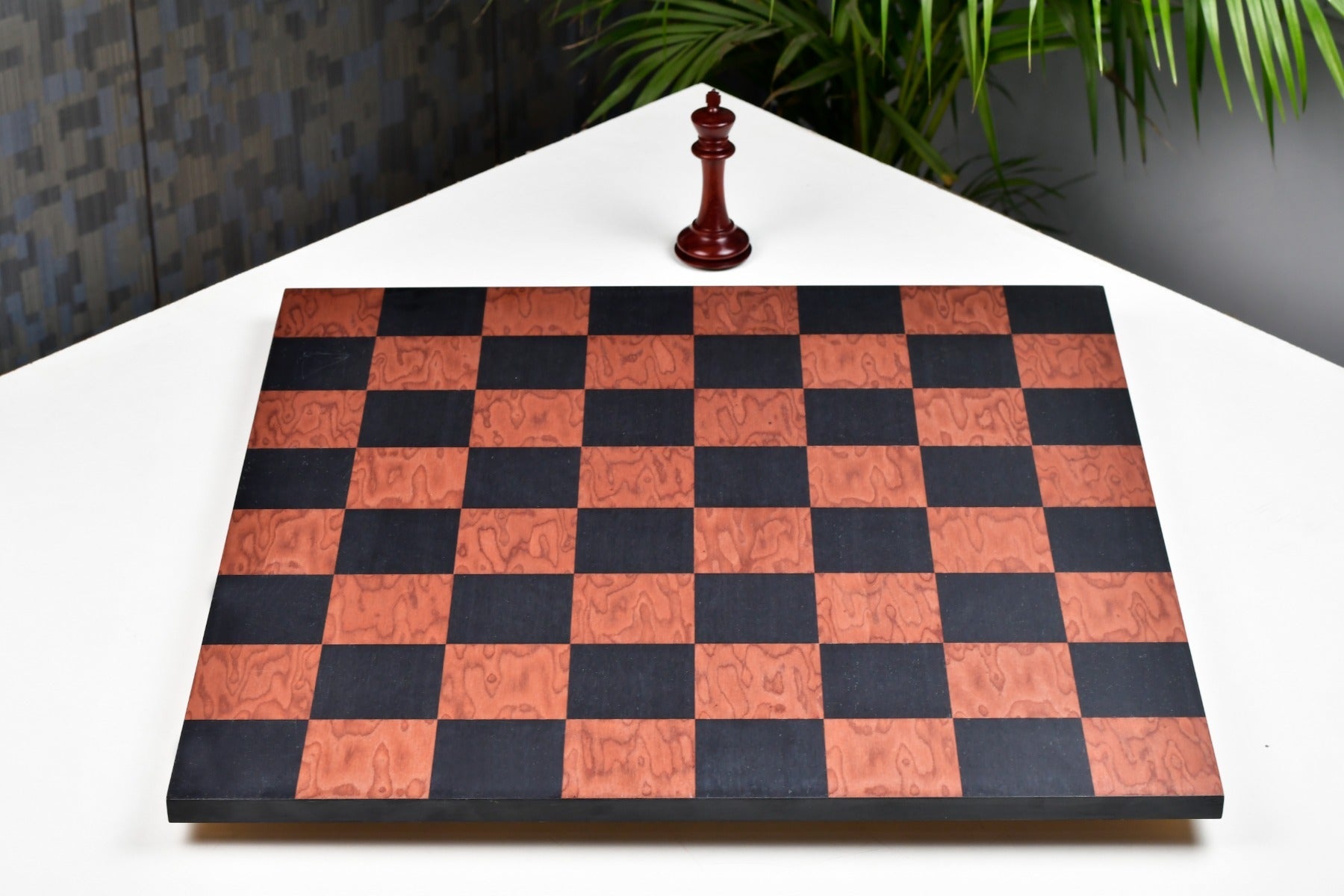 Minimalist black anigre and red ash burl chess board at an angle