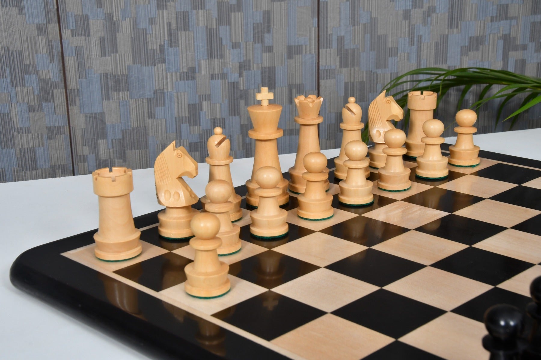 Ebonised chess pieces set up for play on the included 48cm solid ebony and maple board