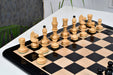 Ebonised chess pieces set up for play on the included matching wooden board