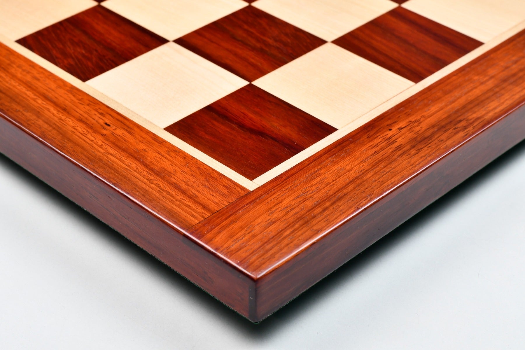 Blood red bud rosewood chess board showing its 22mm thickness