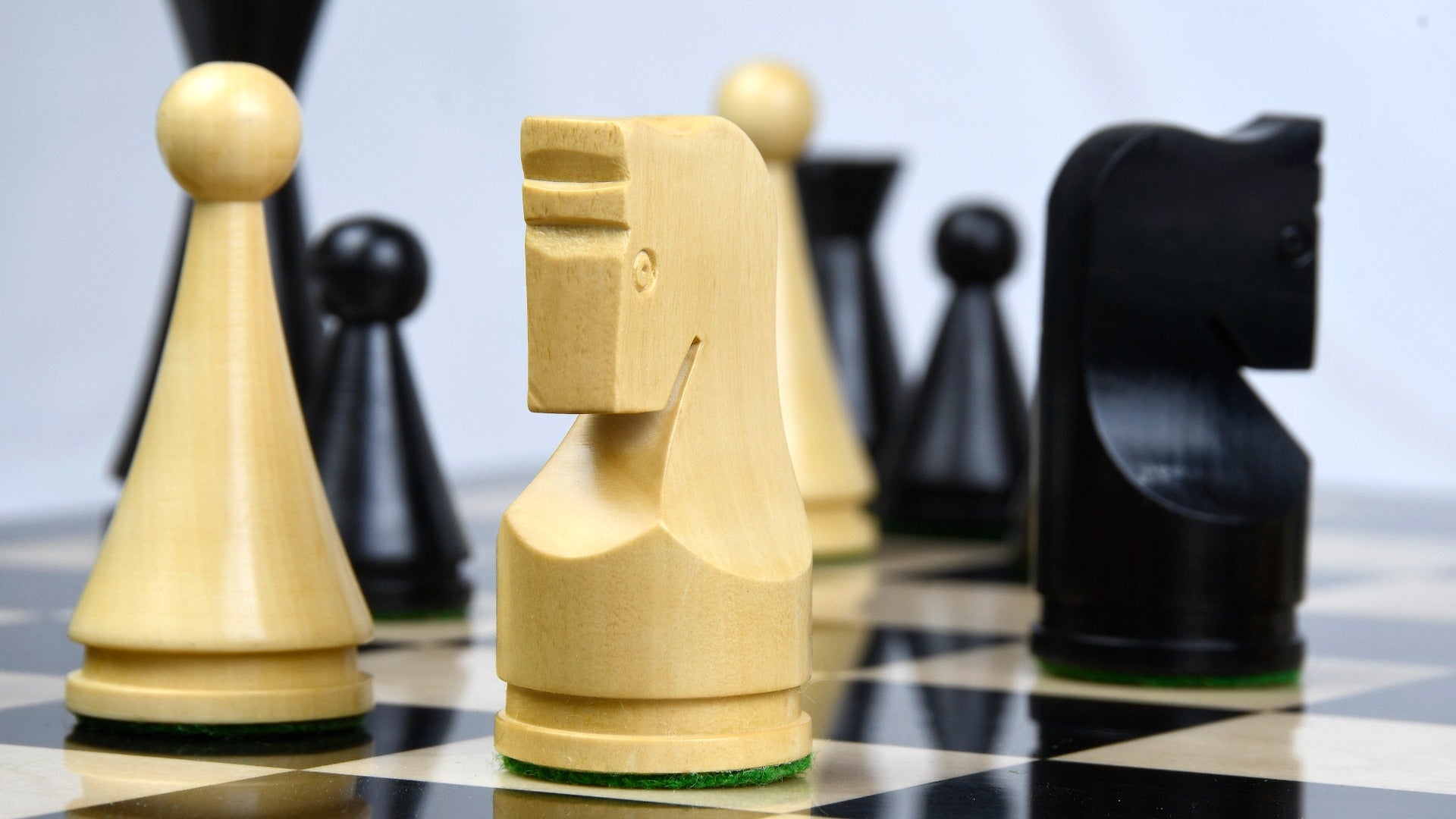 Ebonised chess pieces set up for play on the included 48cm ebony and maple board