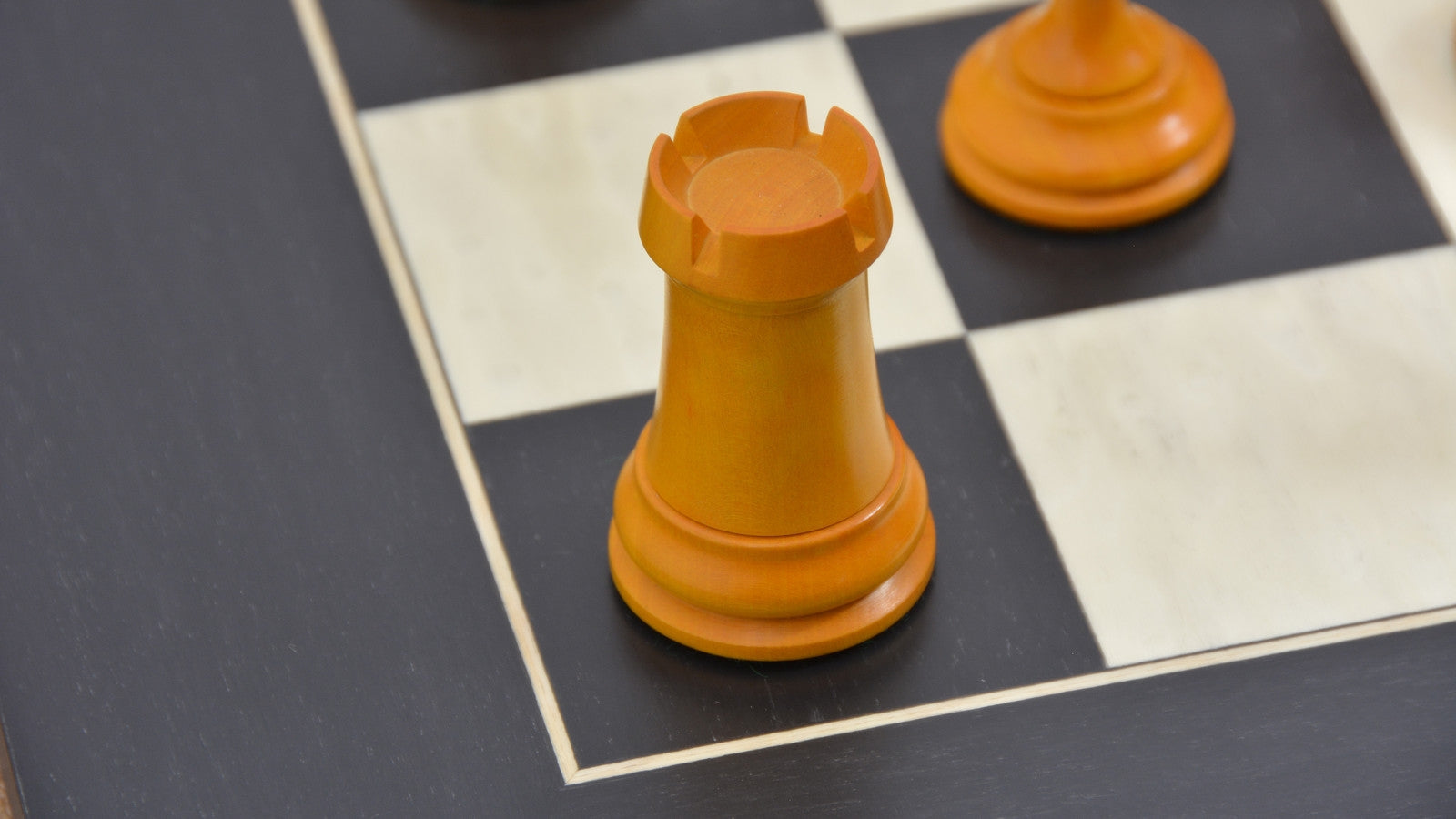 Genuine ebony chess pieces set up for play on the included 60cm black anigre and maple board