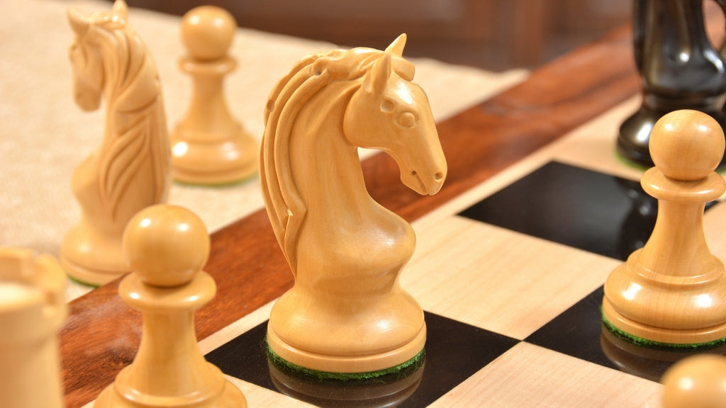 Genuine ebony chess pieces set up for play on the included 58cm ebony and maple board with a sheesham border