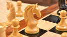 Genuine ebony chess pieces set up for play on the included 58cm ebony and maple board with a sheesham border