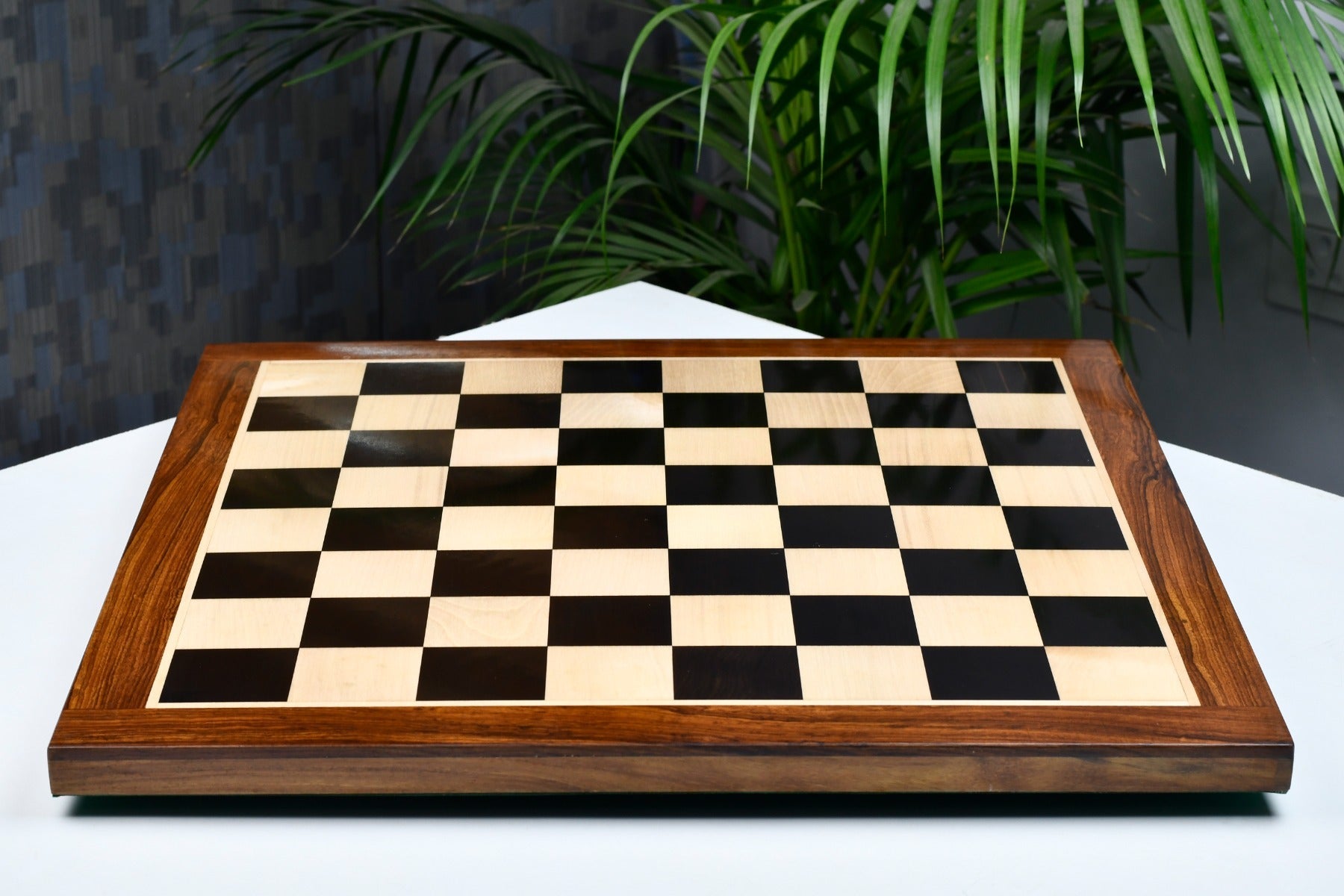 Ebony and maple chess board showing its 25mm thickness