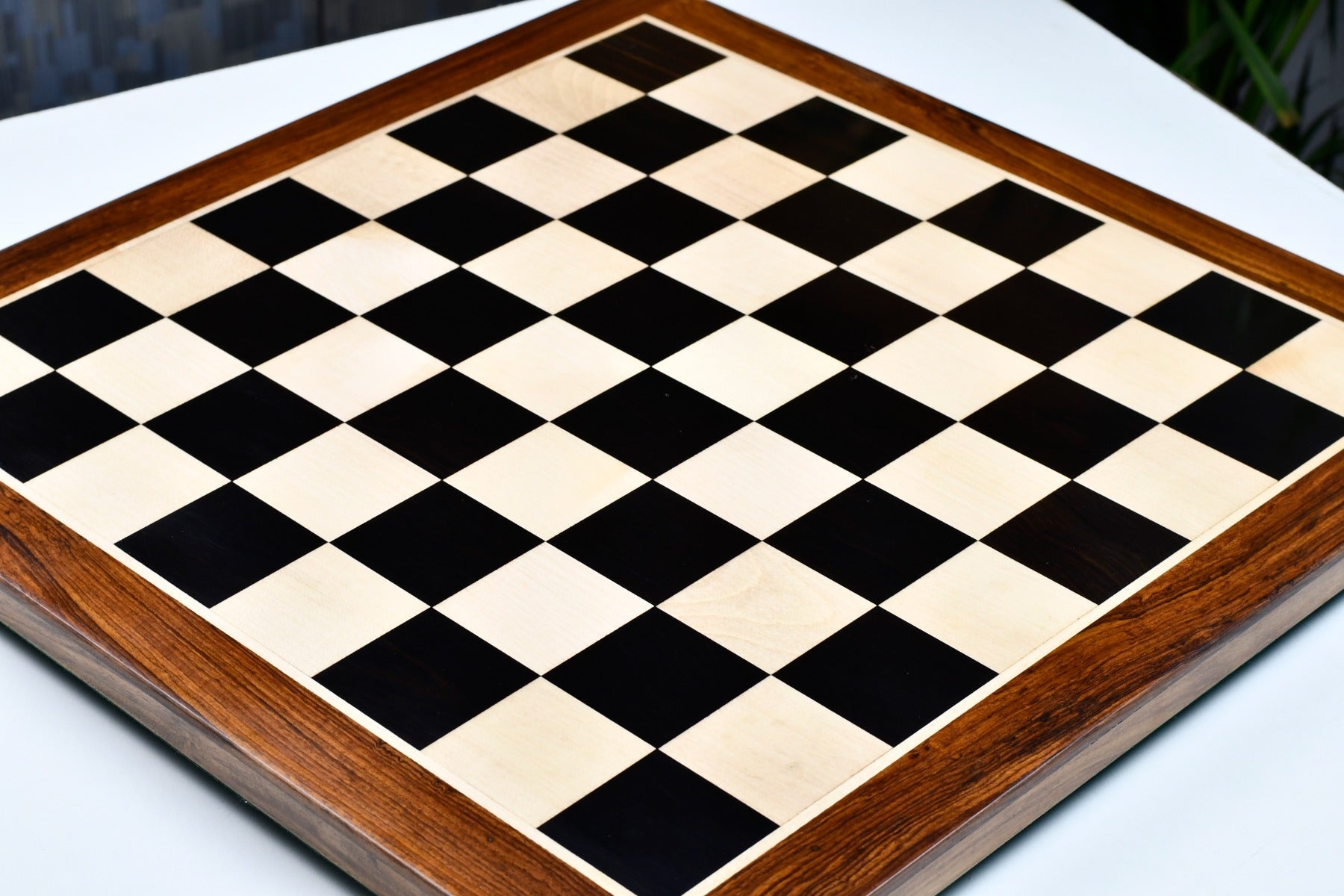 Ebony and maple sheesham border 55mm square chess board at an angle