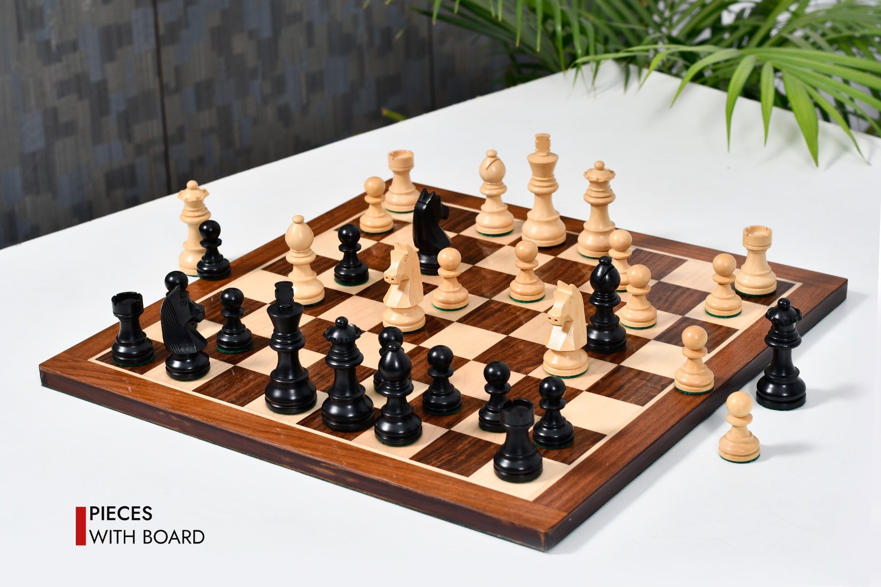 Ebonised chess pieces set up for play on the included 37cm sheesham and boxwood board