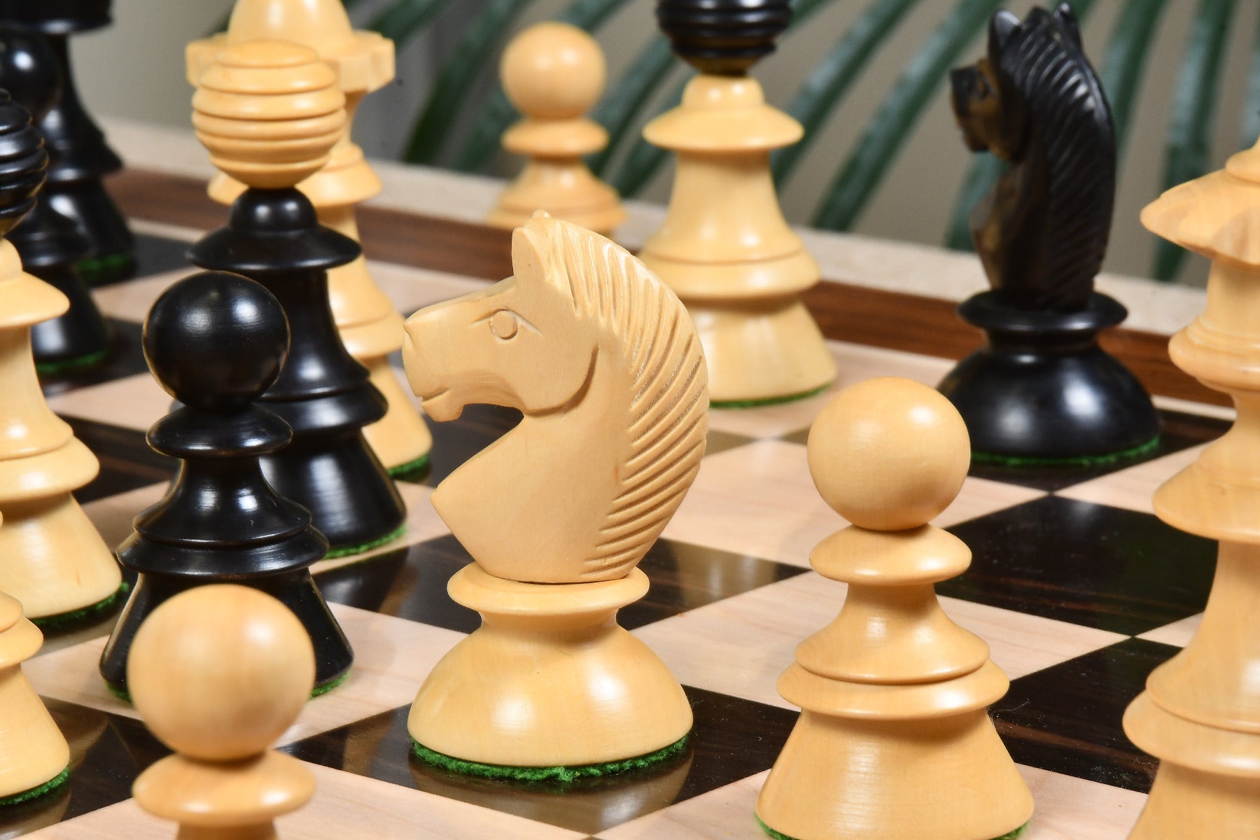 Ebonised chess pieces with a 107mm king and weighted felted bases