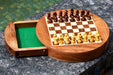 Travel round magnetic chess set with the drawer pulled out beneath the playing surface