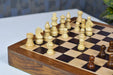 Rosewood chess pieces set up for play on the included 30cm rosewood and maple travel board