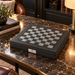 Dal Rossi carbon fibre chess board on a dark marble table