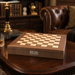 Dal Rossi walnut inlaid 50cm chess board on a table beside a leather armchair