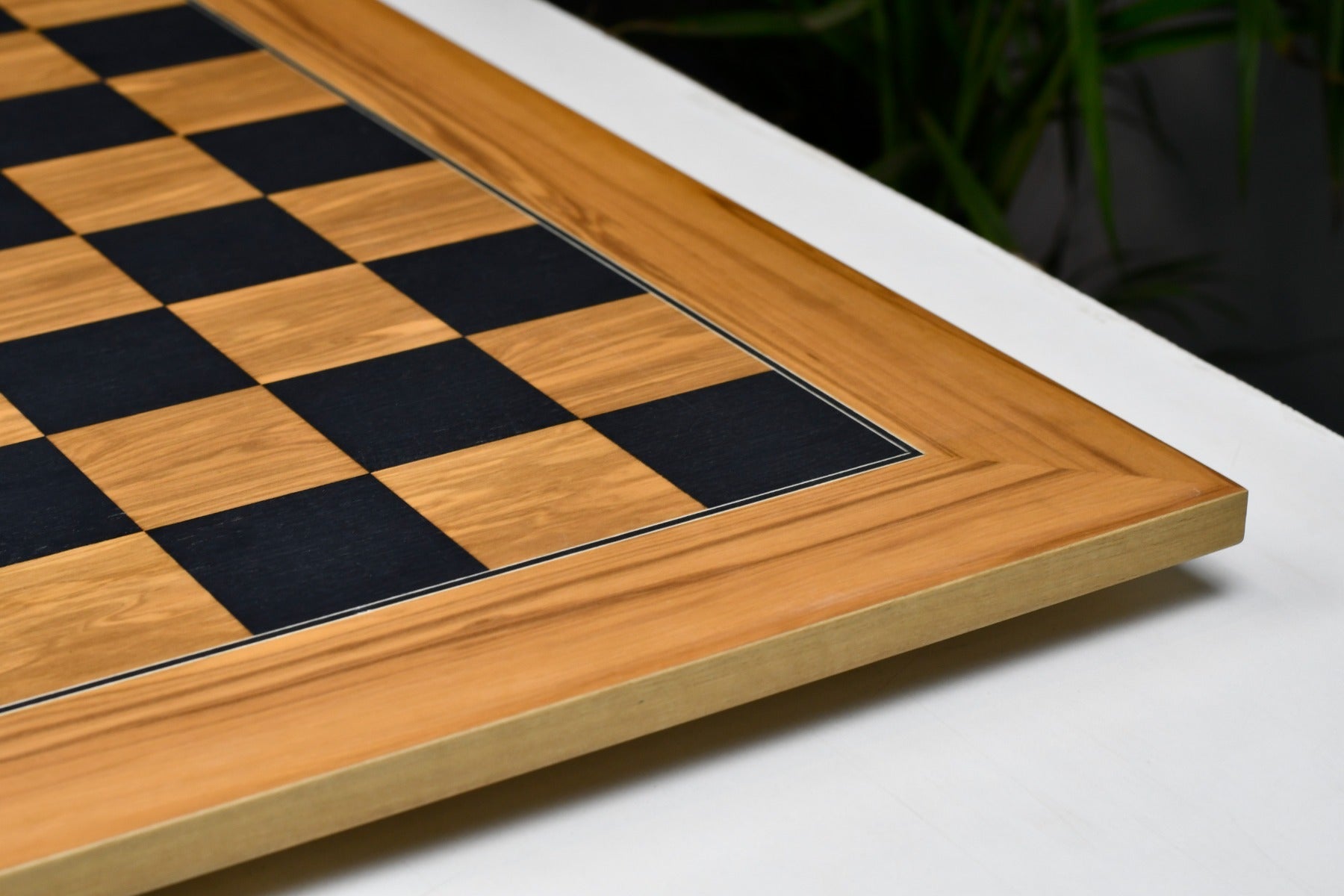 Black dyed poplar and olive chess board at an angle